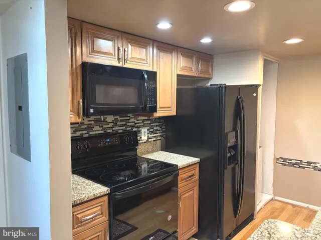 a kitchen with granite countertop stainless steel appliances and refrigerator
