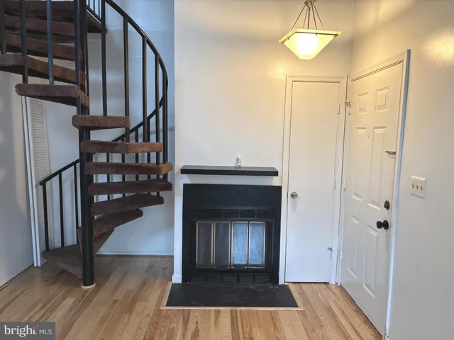 a view of a livingroom with wooden floor and staircase