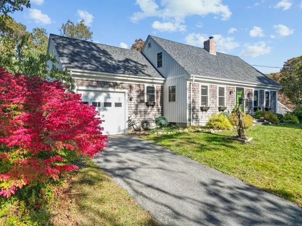 a front view of house and yard with beautiful flowers