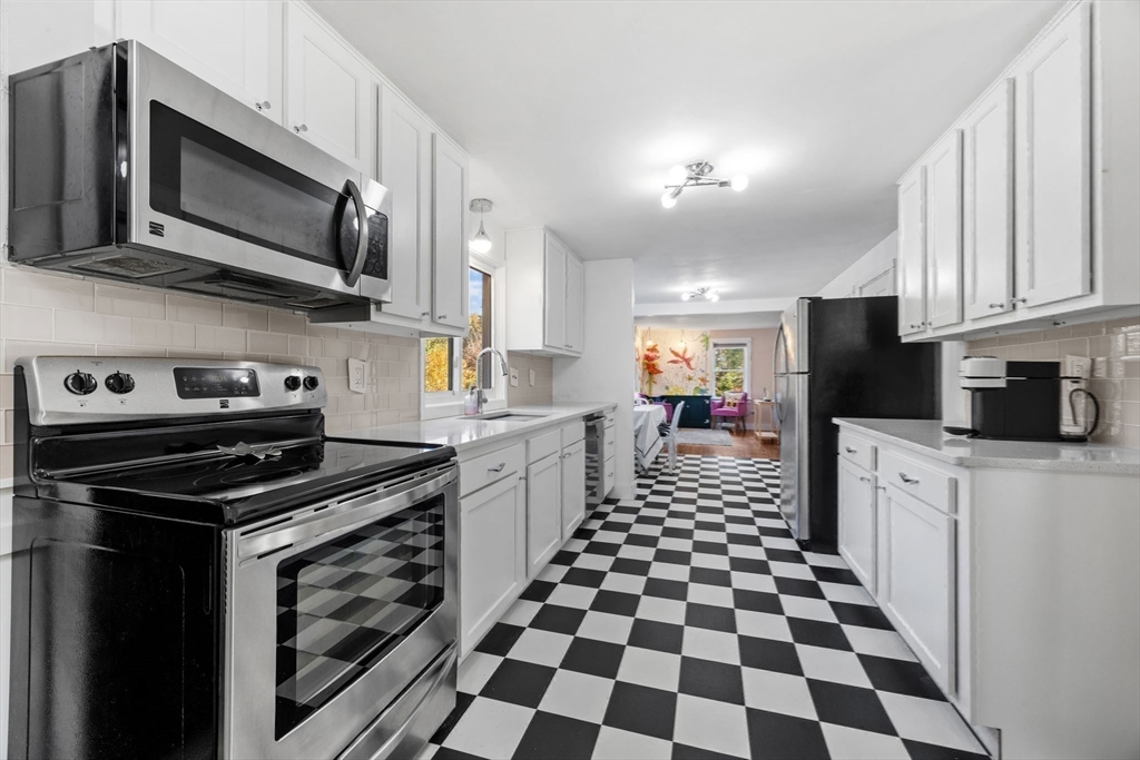 18 Carlton Road Bourne, MA 02532 - Photo 15 of 41 a kitchen with stainless steel appliances a stove a microwave sink and cabinets
