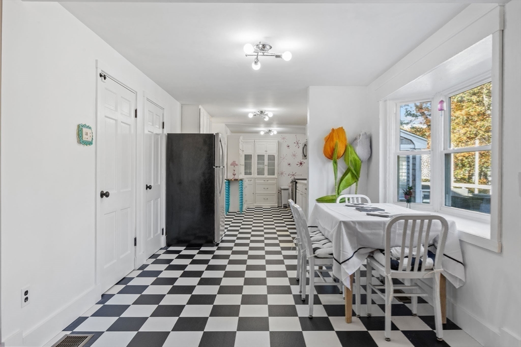 18 Carlton Road Bourne, MA 02532 - Photo 10 of 41 a living room with a black white checkered floor with a gaming machine and dining table