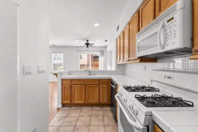 a kitchen with stainless steel appliances granite countertop a stove a sink and a refrigerator