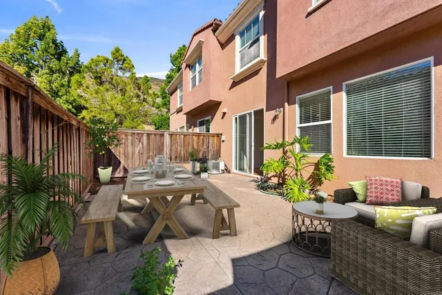 a view of a patio with couches table and chairs and potted plants