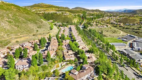 an aerial view of residential houses with outdoor space and trees