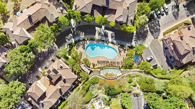 an aerial view of residential houses with outdoor space and trees