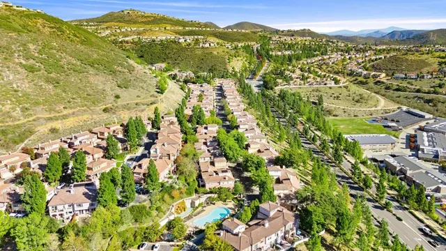 an aerial view of residential houses with outdoor space and trees