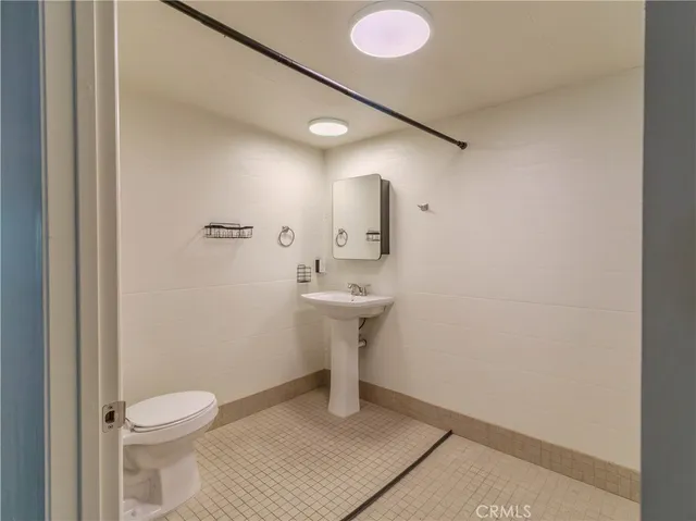 a bathroom with a sink toilet and a mirror