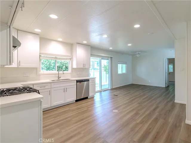 a kitchen with granite countertop a stove top oven a sink a counter space and cabinets