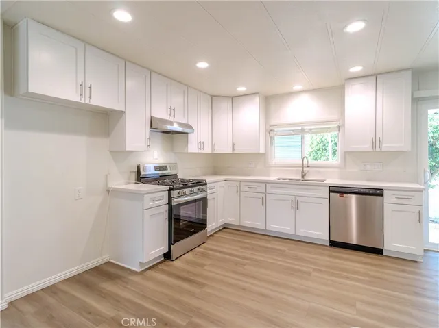 a kitchen with granite countertop white cabinets and white appliances