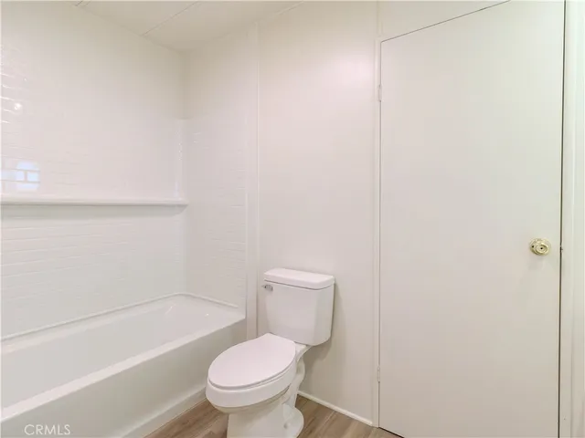 a white toilet sitting next to a bath tub