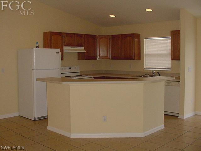 717 Alabama Road South Lehigh Acres, FL 33974 - Photo 3 of 9 a view of kitchen with stainless steel appliances granite countertop a refrigerator sink and cabinets
