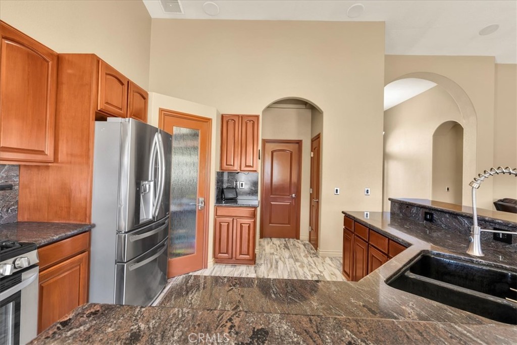 7959 Stephenson Lane Yucca Valley, CA 92284 - Photo 24 of 75 a kitchen with stainless steel appliances granite countertop a refrigerator a stove and a sink
