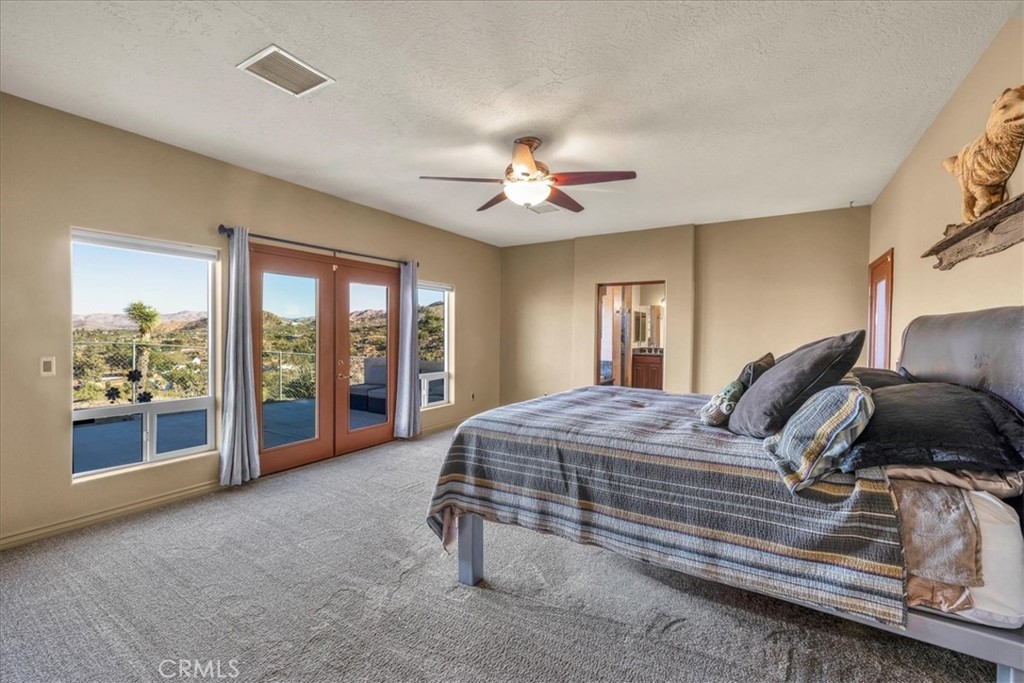 7959 Stephenson Lane Yucca Valley, CA 92284 - Photo 33 of 75 a bedroom with a large bed and a chandelier