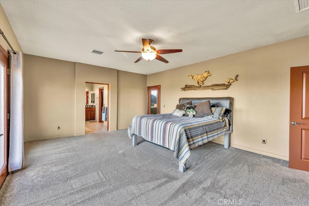 7959 Stephenson Lane Yucca Valley, CA 92284 - Photo 34 of 75 a spacious bedroom with a bed and a chandelier