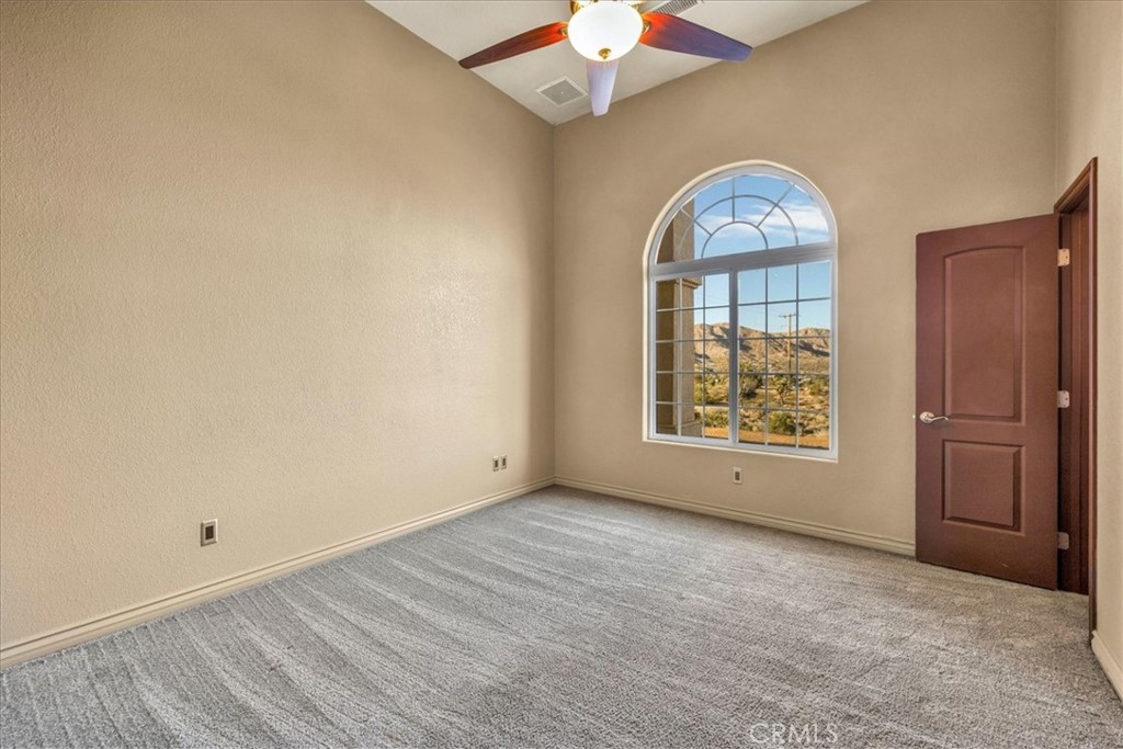 7959 Stephenson Lane Yucca Valley, CA 92284 - Photo 49 of 75 an empty room with windows cabinet and fireplace