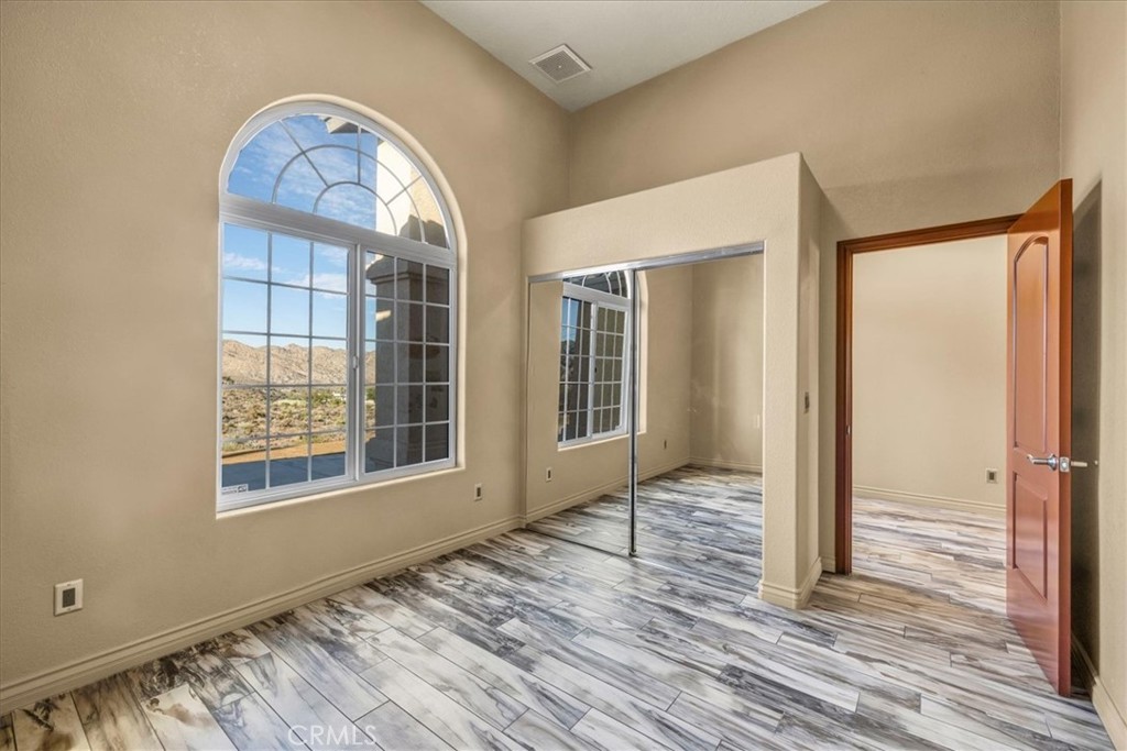 7959 Stephenson Lane Yucca Valley, CA 92284 - Photo 53 of 75 a view of empty room with wooden floor and fan