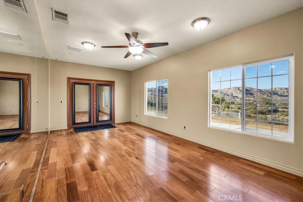 7959 Stephenson Lane Yucca Valley, CA 92284 - Photo 55 of 75 a view of an empty room with a window and wooden floor