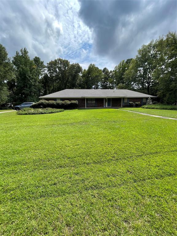 122 Post Oak Drive Mansfield, LA 71052 - Photo 1 of 23 Ranch-style house featuring a carport, a front yard, and view of scattered trees