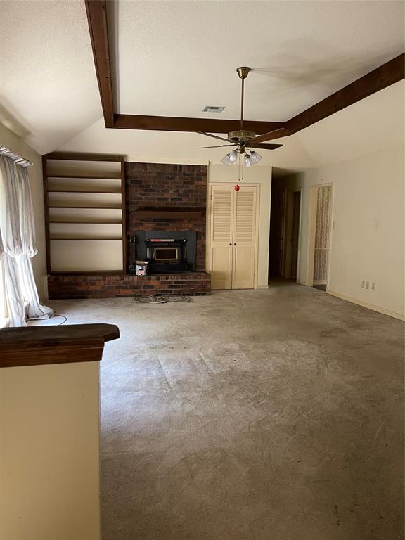 122 Post Oak Drive Mansfield, LA 71052 - Photo 12 of 23 Unfurnished living room featuring carpet, a textured ceiling, a fireplace, and ceiling fan
