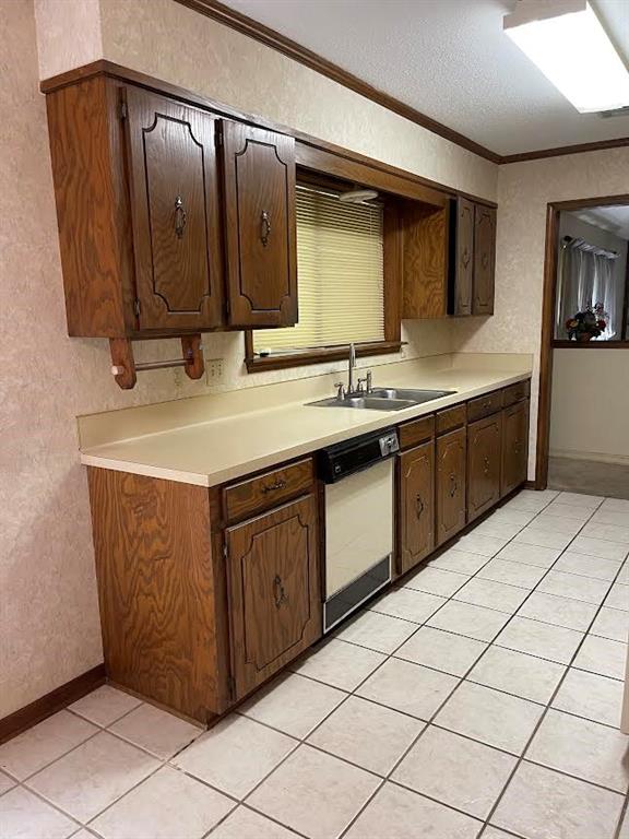 122 Post Oak Drive Mansfield, LA 71052 - Photo 18 of 23 Kitchen featuring light countertops, a textured wall, dark brown cabinets, light tile patterned flooring, and dishwasher