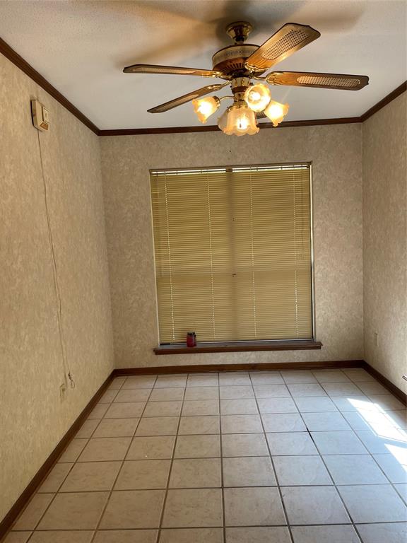 122 Post Oak Drive Mansfield, LA 71052 - Photo 20 of 23 Empty room with wallpapered walls, ornamental molding, light tile patterned flooring, a textured ceiling, and a ceiling fan
