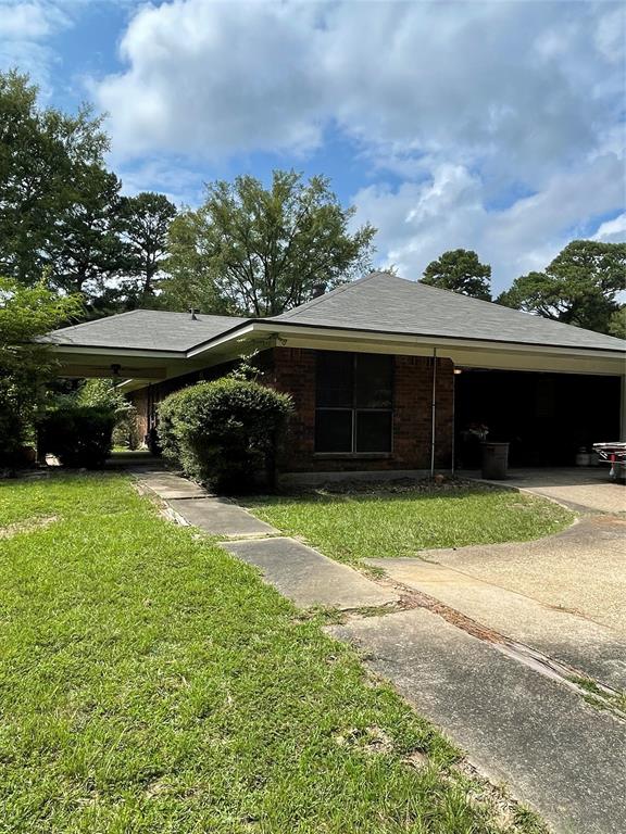 122 Post Oak Drive Mansfield, LA 71052 - Photo 5 of 23 Rear view of property with a lawn, brick siding, roof with shingles, driveway, and a garage
