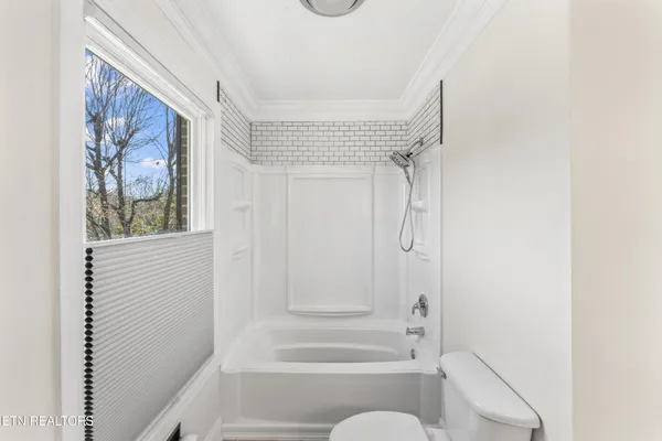 a bathroom with a shower curtain and a window