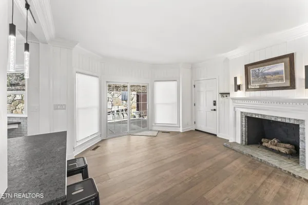 a view of a livingroom with wooden floor and a fireplace