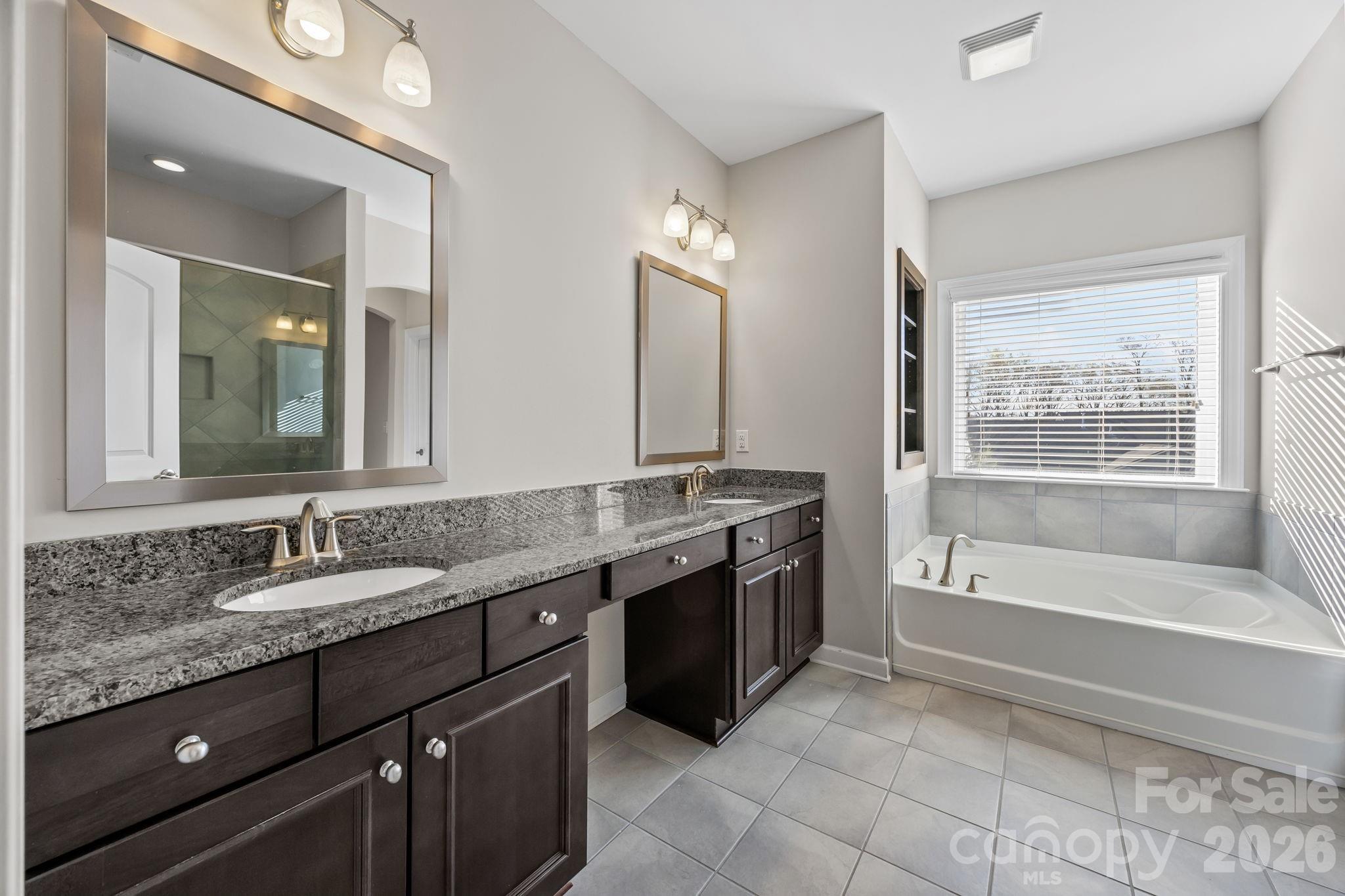 1221 Violet Court Fort Mill, SC 29708 - Photo 31 of 48 a bathroom with a granite countertop double vanity sink a mirror and a bathtub