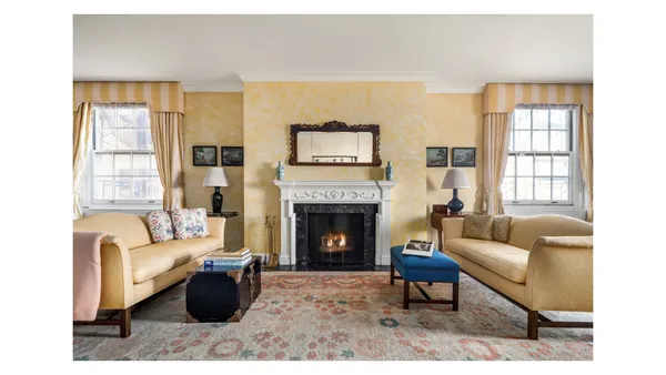 a living room with furniture a fireplace and a large window