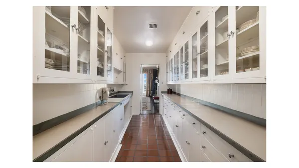 a kitchen with granite countertop a stove cabinets and living room view