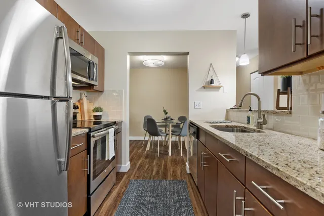 a kitchen with granite countertop a refrigerator stove and sink