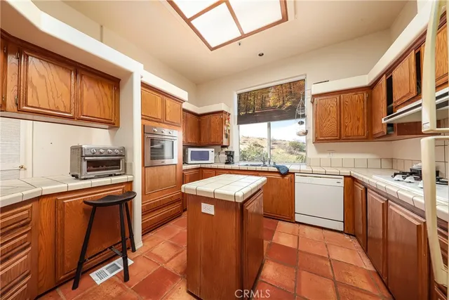 a kitchen with stainless steel appliances granite countertop wooden cabinets a stove top oven a sink and dishwasher