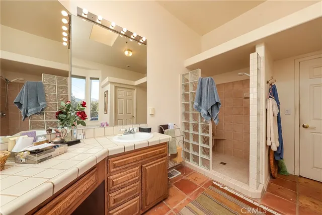 a bathroom with a double vanity sink mirror and shower