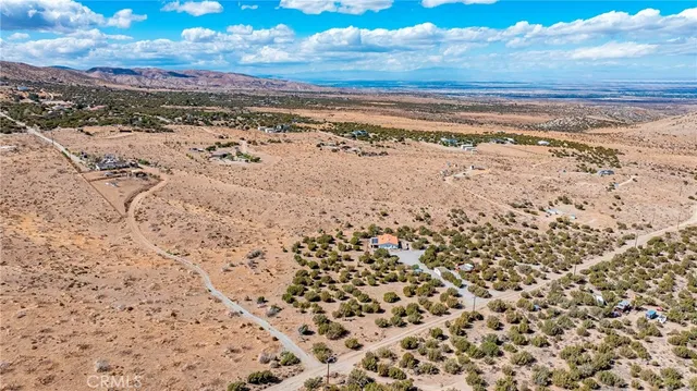 an aerial view of a house with a yard and wooden fence