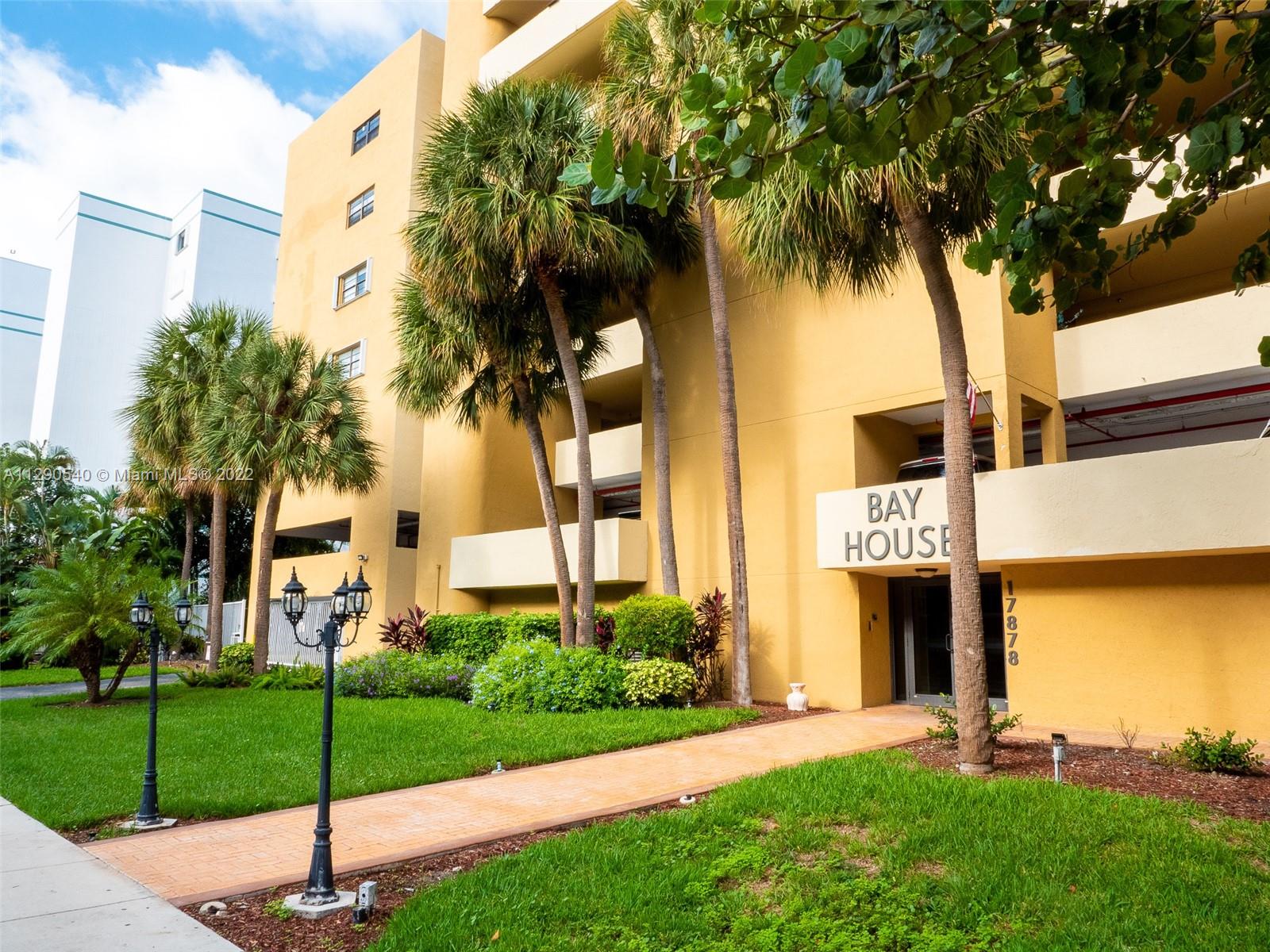 17878 North Bay Road, Unit 306 Sunny Isles Beach, FL 33160 - Photo 3 of 20 a sign board with the garden and tall trees