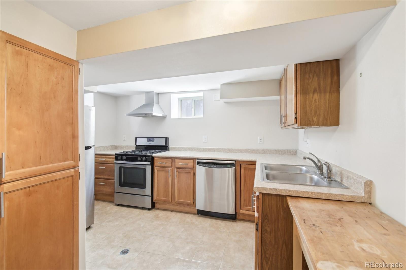 1462 Eudora Street Denver, CO 80220 - Photo 21 of 38 a kitchen with stainless steel appliances granite countertop a sink stove and refrigerator