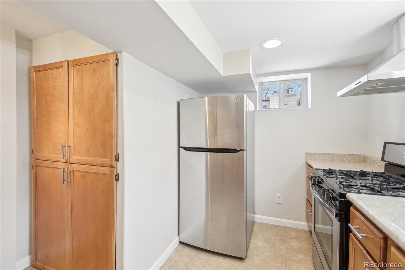 1462 Eudora Street Denver, CO 80220 - Photo 22 of 38 a kitchen with a refrigerator and a stove top oven