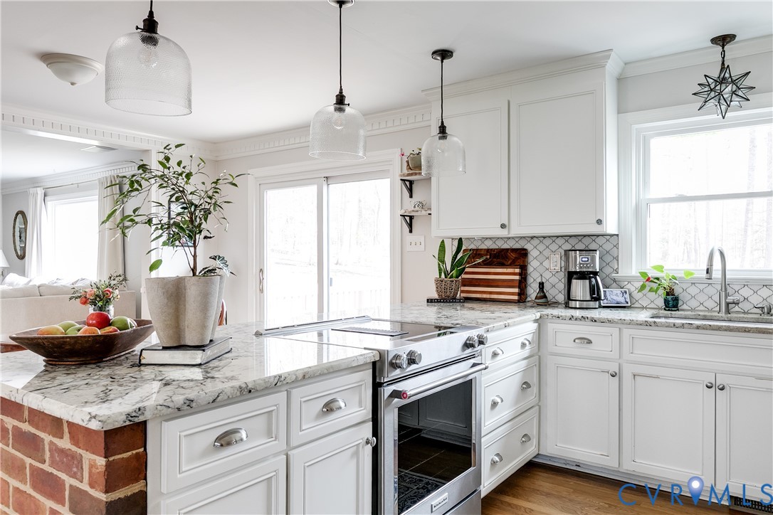 2021 Swamp Fox Road Midlothian, VA 23112 - Photo 21 of 73 a kitchen with stainless steel appliances granite countertop a sink stove and white cabinets next to a window
