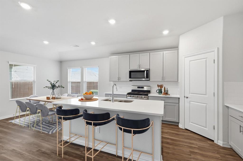 2140 Bellatrix Drive Haslet, TX 76052 - Photo 5 of 33 a kitchen with stainless steel appliances a stove a sink a dining table and chairs