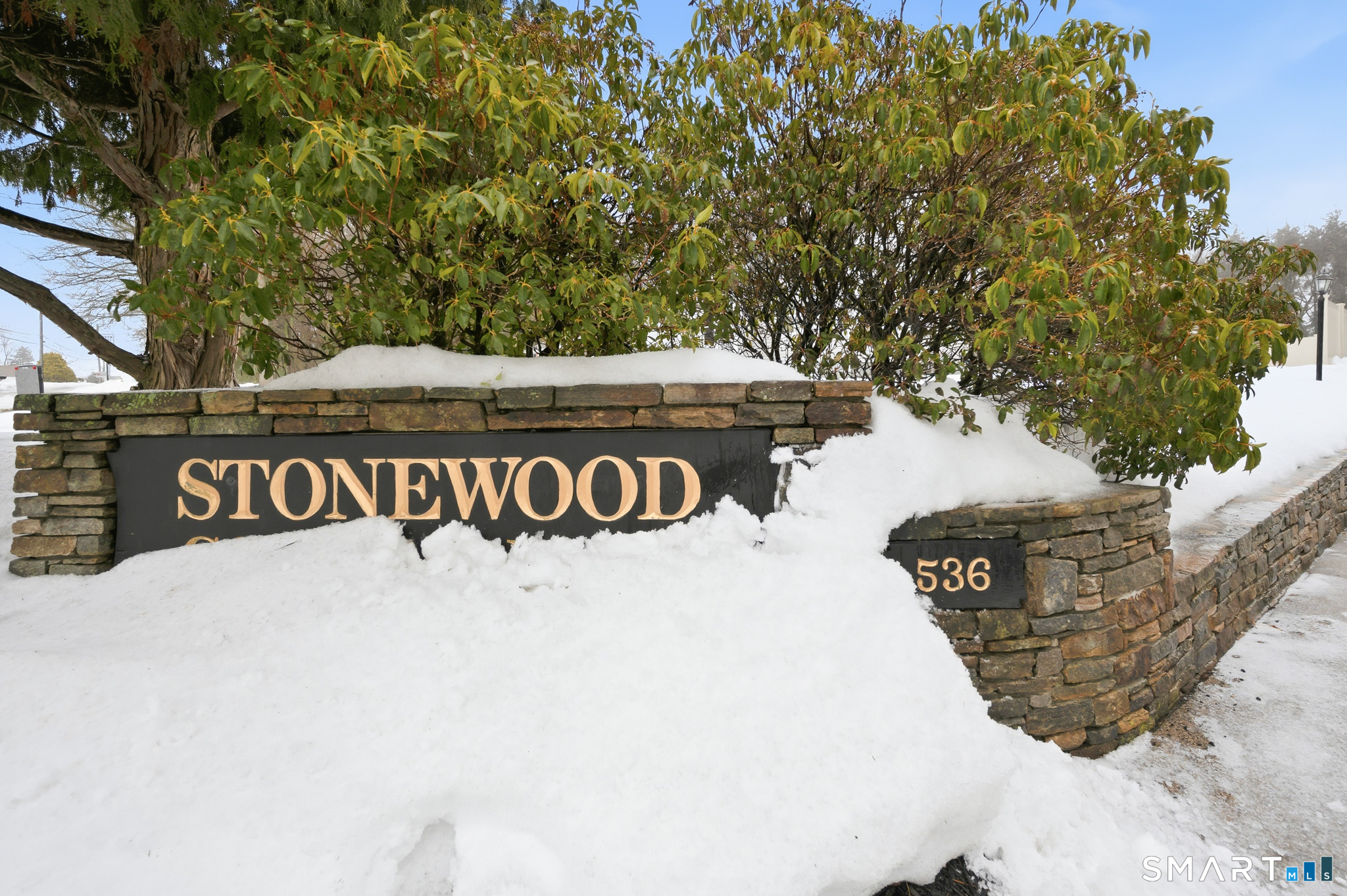 536 Redstone Hill Road, Unit 24 Bristol, CT 06010 - Photo 19 of 27 a view of a street sign under a large tree