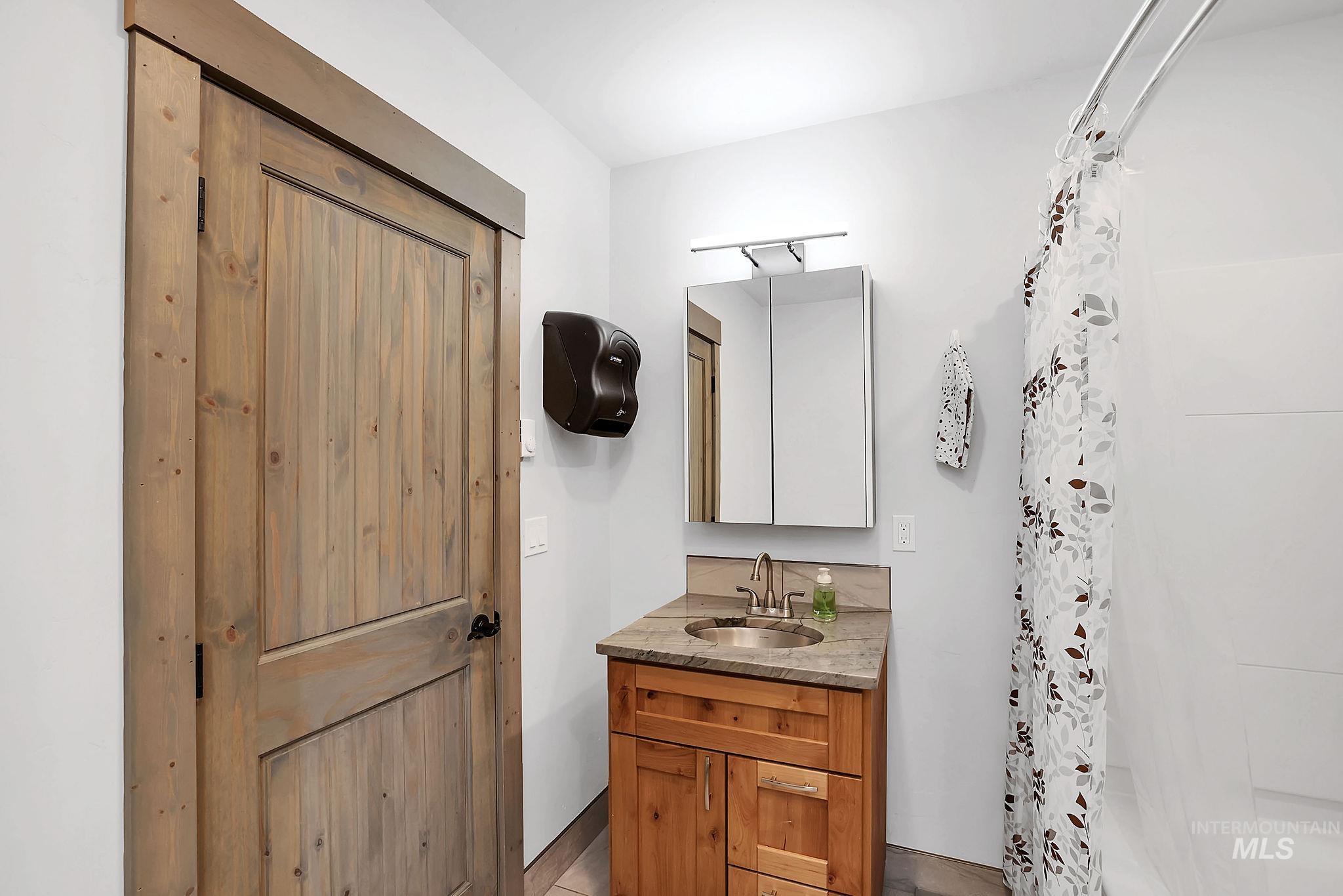 715 Spruce Street McCall, ID 83638 - Photo 18 of 37 Bathroom featuring vanity and curtained shower