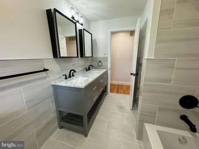 a bathroom with a tub sink and mirror