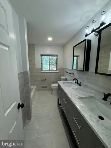 a bathroom with double vanity sink and mirror