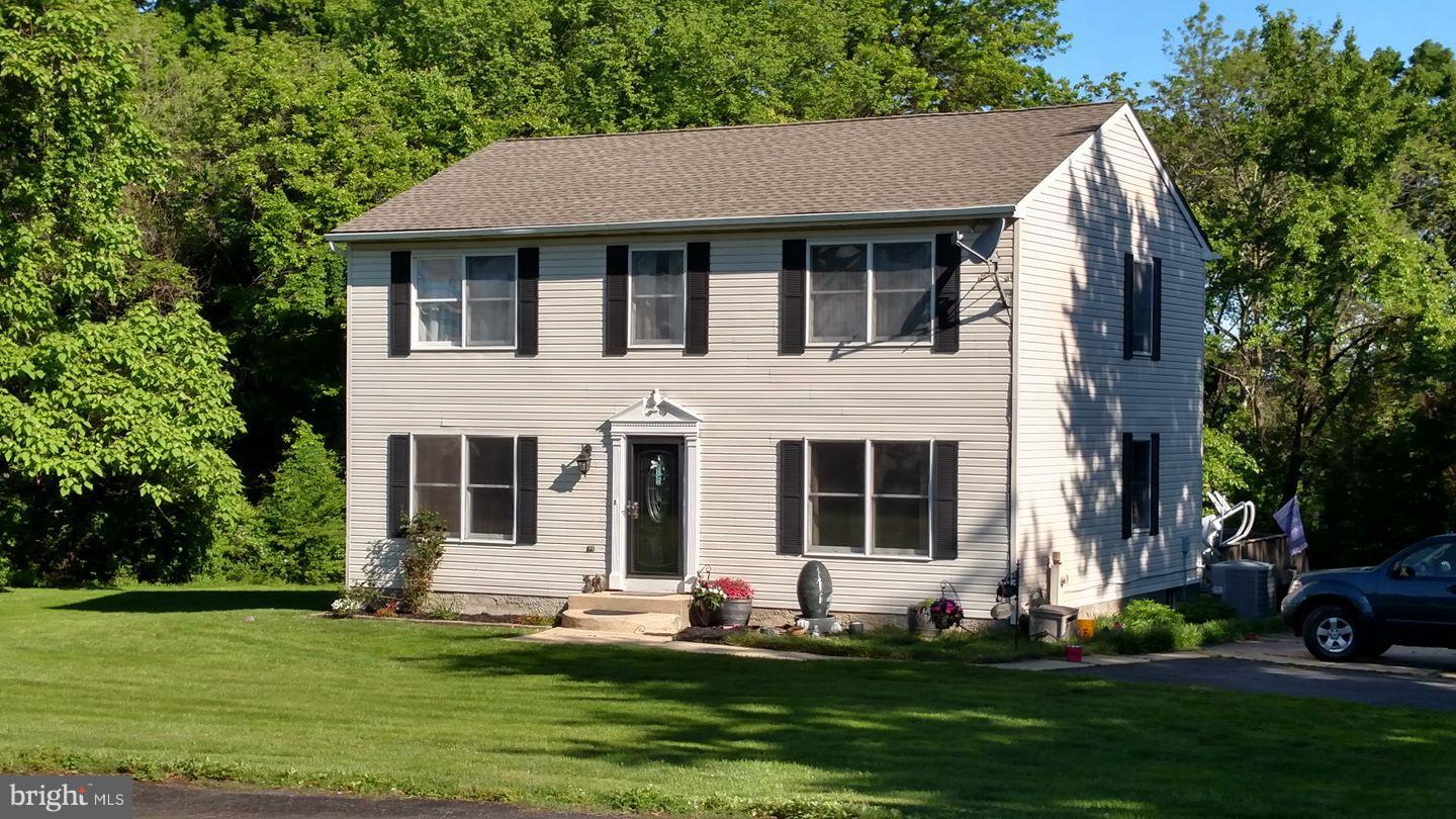 8126 Old Philadelphia Road Baltimore, MD 21237 - Photo 2 of 30 a front view of a house with a garden and trees