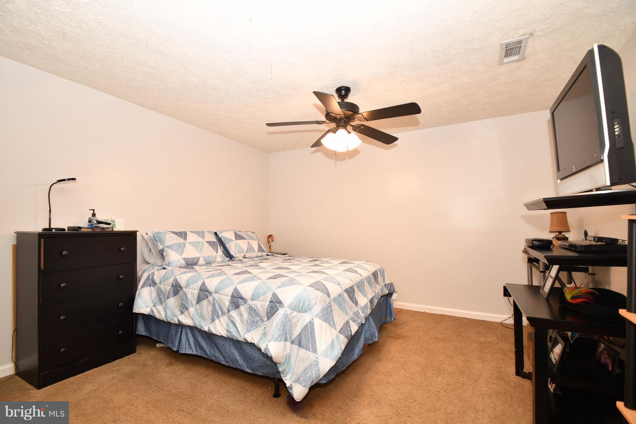 8126 Old Philadelphia Road Baltimore, MD 21237 - Photo 21 of 30 a bedroom with a bed and a chandelier