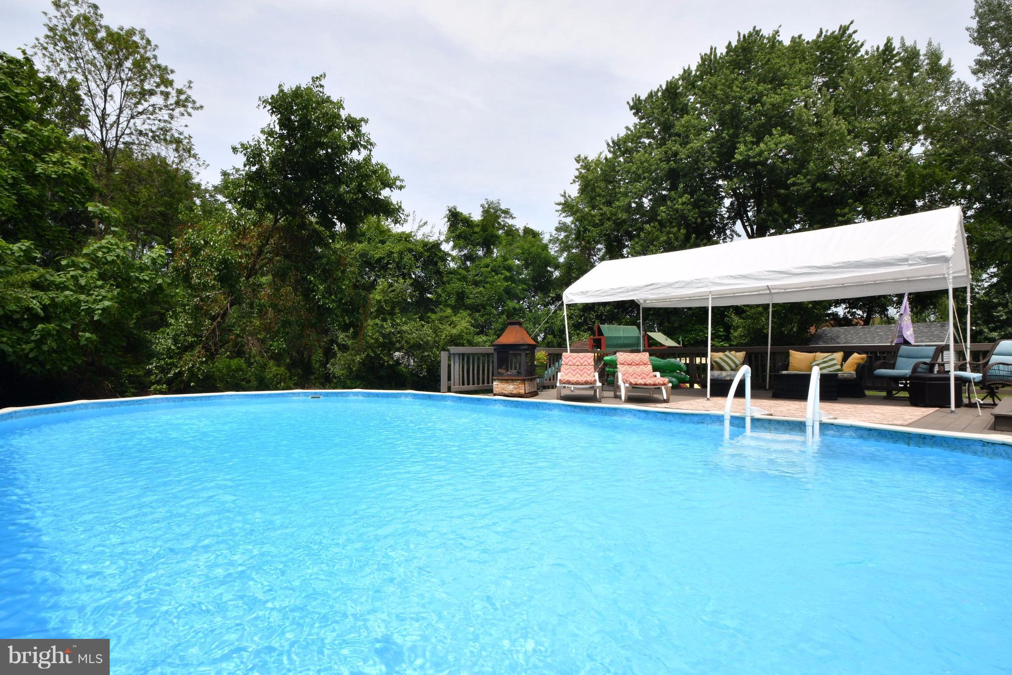 8126 Old Philadelphia Road Baltimore, MD 21237 - Photo 25 of 30 a view of a swimming pool with lawn chairs under an umbrella