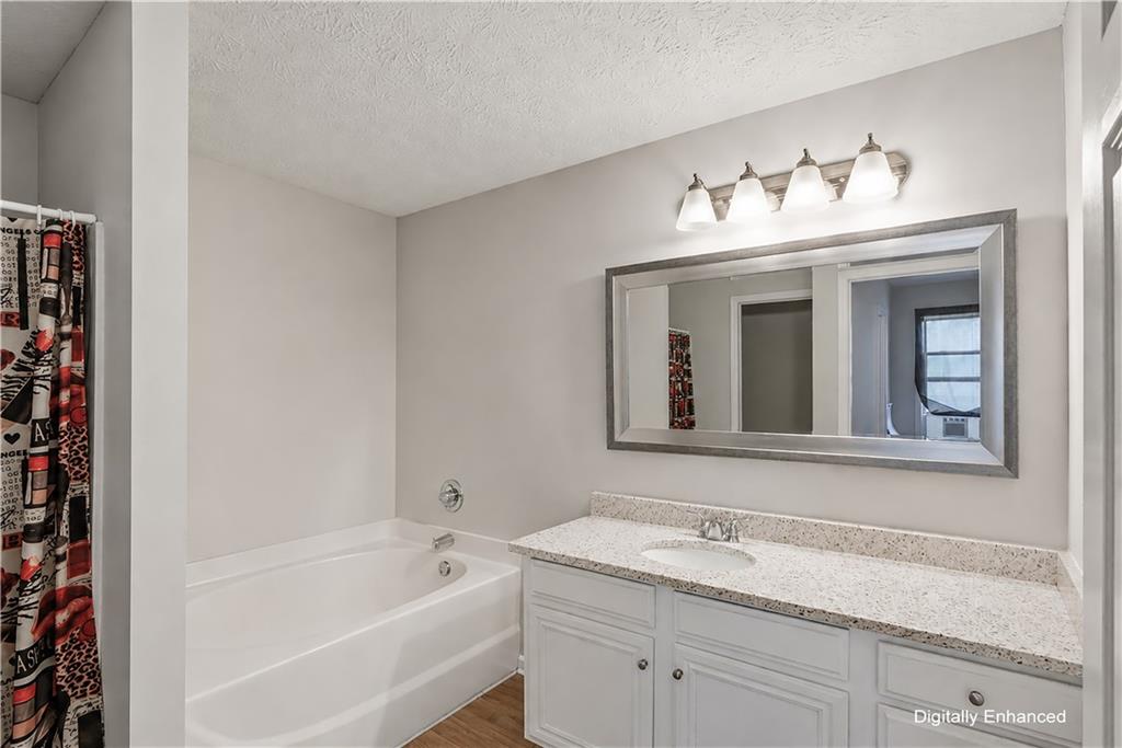 2555 Flat Shoals Road, Unit 2008 Atlanta, GA 30349 - Photo 24 of 33 a bathroom with a sink double vanity granite tub and a mirror