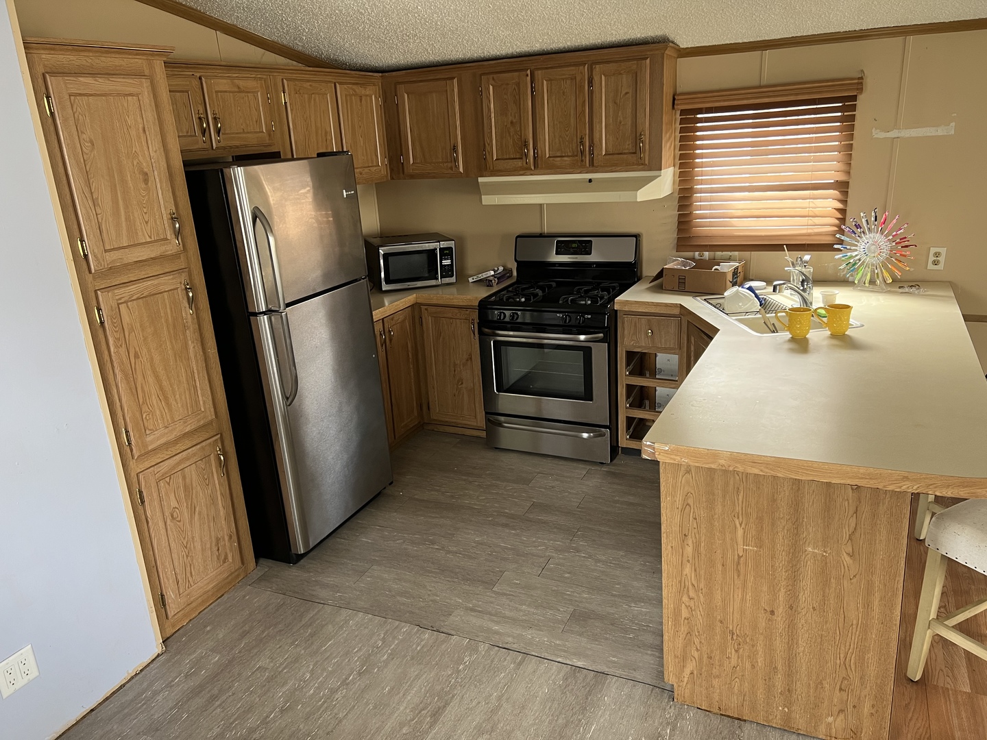 240 Whitney Road, Unit 21 Lake Zurich, IL 60047 - Photo 3 of 13 a kitchen with stainless steel appliances a refrigerator sink and stove