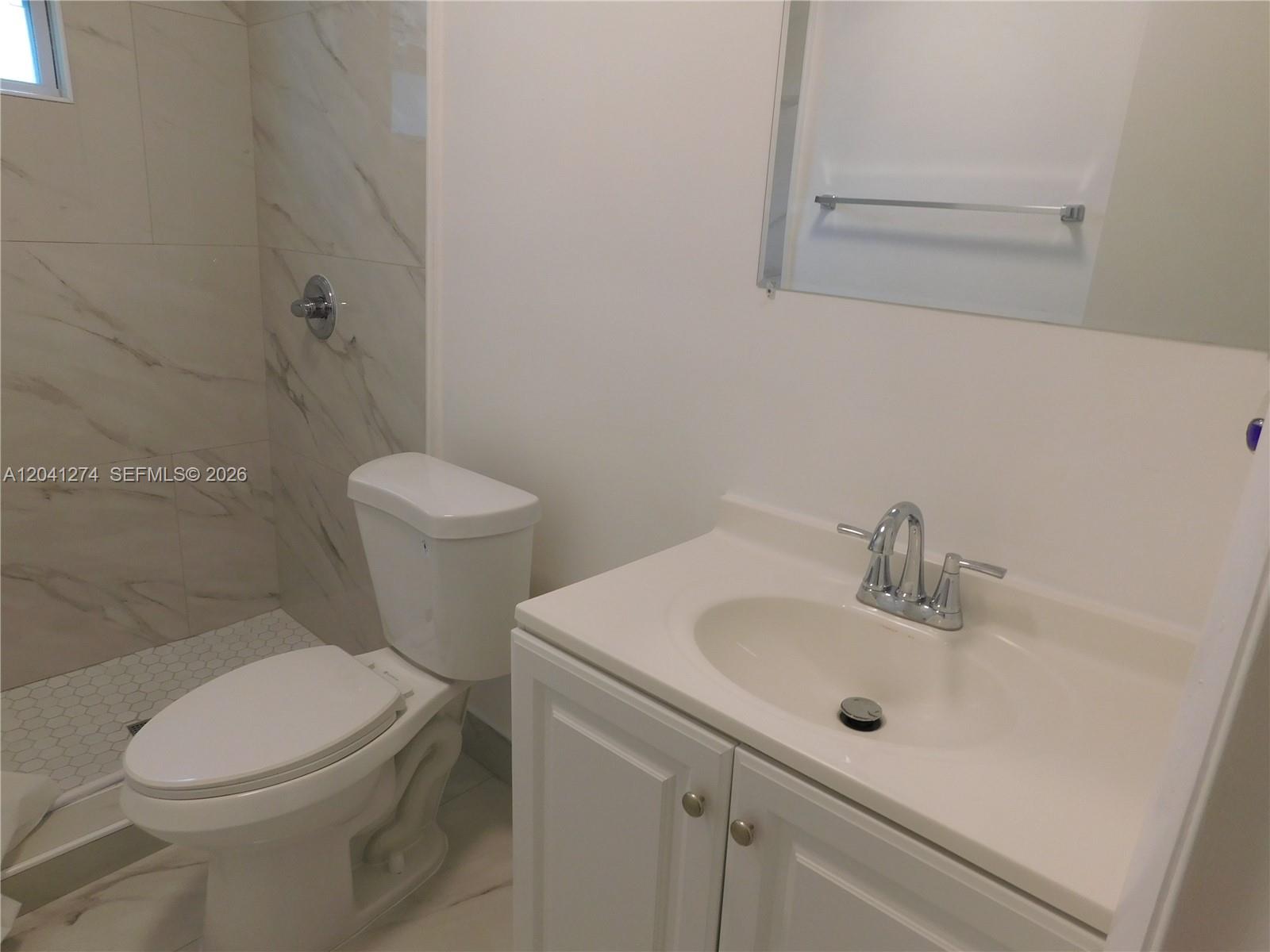 2230 Northwest 58th Street, Unit B Miami, FL 33142 - Photo 12 of 18 a white toilet sitting next to a bathroom sink